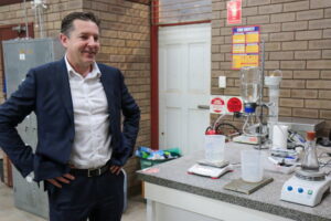 Man posing next to equipment in a laboratory.