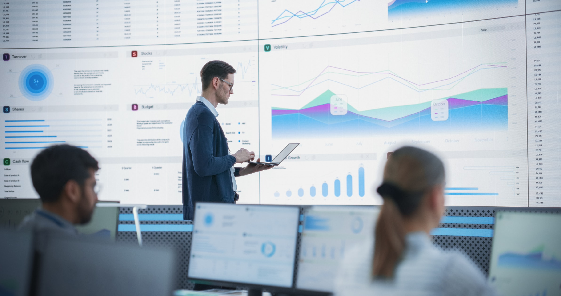 A man examines a screen displaying investment graphs and data trends.